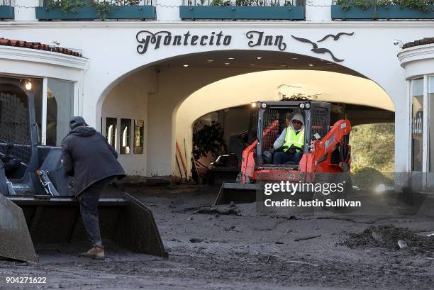 Workers clear mud from the parking garage at the Montecito Inn following a mudslide on January 12, 2018 in Montecito, California. 17 people have died...