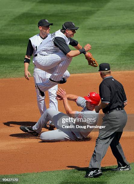Shortstop Troy Tulowitzki of the Colorado Rockies turns a double play on Scott Rolen of the Cincinnati Reds on a ball hit by Jonny Gomes to second...