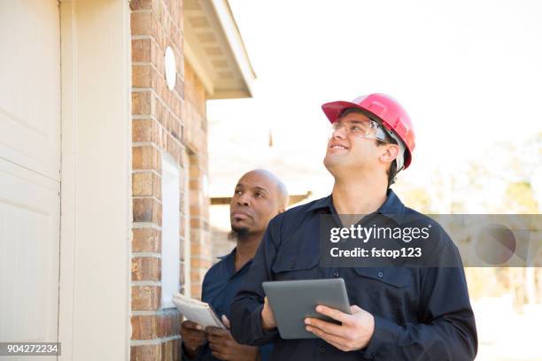 home inspectors examine recent construction using digital tablet. - inspectors stock pictures, royalty-free photos & images