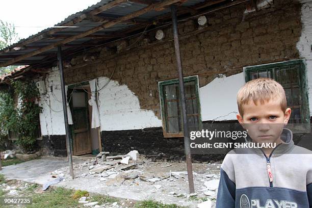 An Albanian boy stands outside his damaged house is pictured following the recent earthquake in Shupenz near Peshkopi, some 200 km north east from...