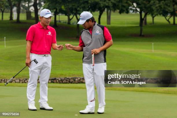 Sunghoon Kang is seen discussing a strategy with his pairing Poom Saksansin on fourball matches at the EurAsia Cup. EurAsia Cup is a biennial men...