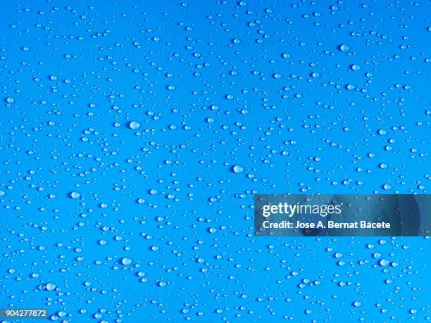 full frame of the textures formed by the bubbles and drops of water, on a smooth  blue background. - frosty foto e immagini stock