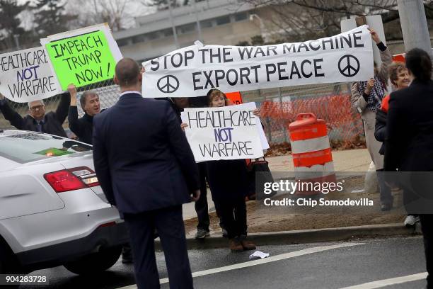 Protesters gather outside Walter Reed National Military Medical Center as U.S. President Donald Trump arrives his annual physical examination January...