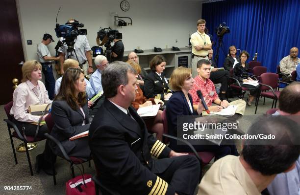 Photograph showing Wall Street Journal reporter Betsy McKay among other reporters seated at a CDC news conference, directing a question to the CDC...