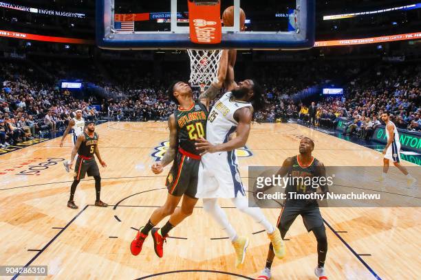John Collins of the Atlanta Hawks attempts to block Kenneth Faried of the Denver Nuggets at the Pepsi Center on January 10, 2018 in Denver, Colorado....