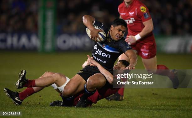 Bath player Ben Tapuai is tackled by Scarlets player James Davies the European Rugby Champions Cup match between Bath Rugby and Scarlets at...