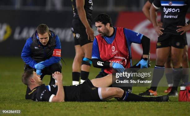 Bath player Rhys Priestland receives treatment before leaving the field with an injury during the European Rugby Champions Cup match between Bath...