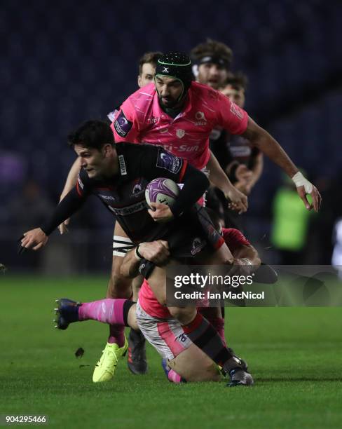 Sam Hidalgo-Clyne of Edinburgh Rugby is tackled by Matthieu Ugena of Stade Francais Paris during the European Rugby Challenge Cup match between...