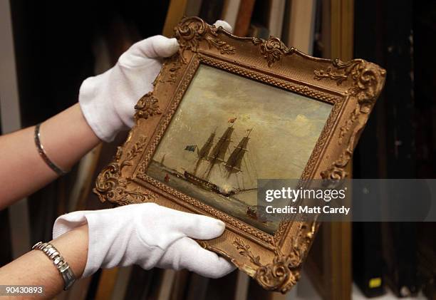 Jenny Wittamore, assistant curator at the National Maritime Museum Cornwall, inspects a rare painting that is currently being kept at the museum...