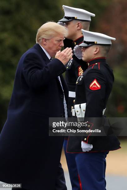 President Donald Trump salutes before boarding Marine One on departure from Walter Reed National Military Medical Center following his annual...