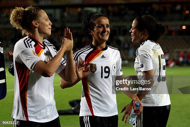 Kim Kulig of Germany celebrates with Fatmire Bajramaj and Celia Okoyino da Mbabi after winning the UEFA Women's Euro 2009 Semi-Final match between...