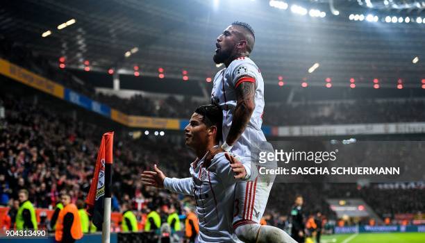 Bayern Munich's midfielder James Rodriguez celebrates after scoring with Bayern Munich's Chilean midfielder Arturo Vidal during the German First...