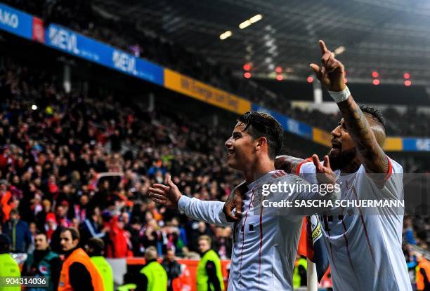 Bayern Munich's midfielder James Rodriguez celebrates after scoring with Bayern Munich's Chilean midfielder Arturo Vidal during the German First...