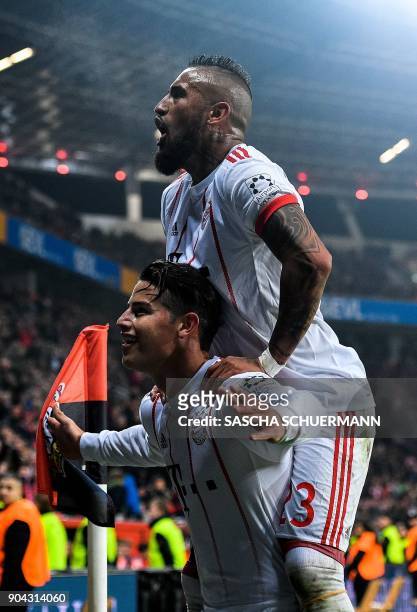 Bayern Munich's midfielder James Rodriguez celebrates after scoring with Bayern Munich's Chilean midfielder Arturo Vidal during the German First...