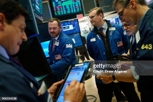 Traders and financial professional work ahead of the closing bell on the floor of the New York Stock Exchange , January 12, 2018 in New York City....