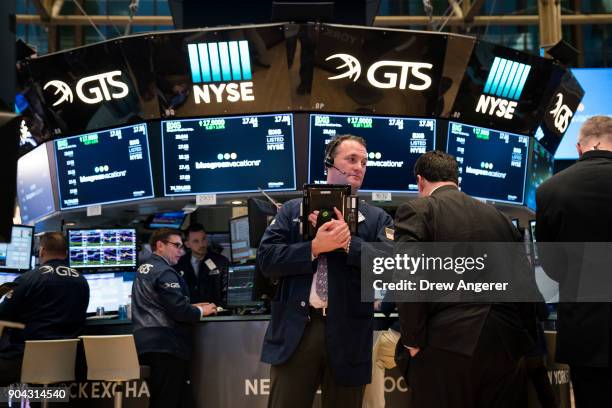 Traders and financial professional work ahead of the closing bell on the floor of the New York Stock Exchange , January 12, 2018 in New York City....