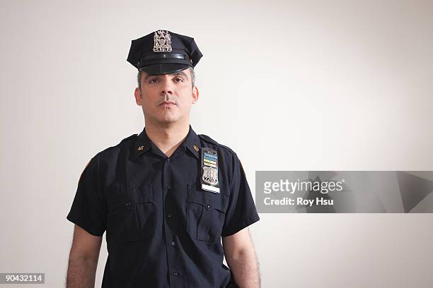 portrait of hispanic police officer - police hat stock pictures, royalty-free photos & images