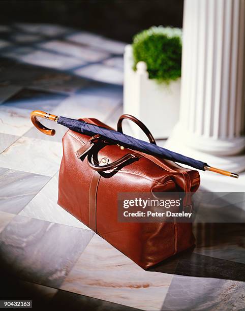 leather overnight bag with rolled up umbrella. - sac en cuir photos et images de collection