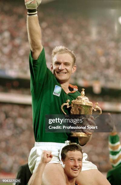 Chaired by Ollie le Roux, Francois Pienaar of South Africa holds the trophy following their 15-12 victory in the Rugby Union World Cup Final against...