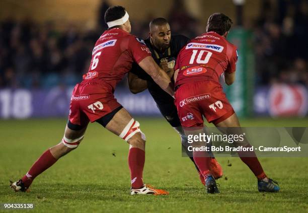 Bath Rugby's Aled Brew is tackled by Scarlets Aaron Shingler and Dan Jones during the European Rugby Champions Cup match between Bath Rugby and...