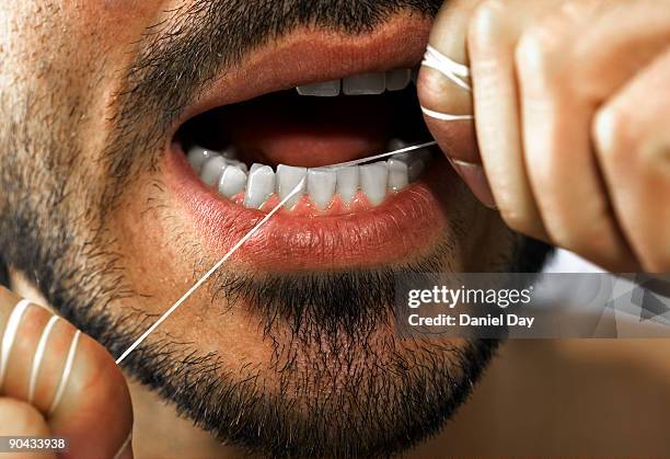 man flossing teeth - zahnseide stock-fotos und bilder