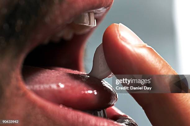 man placing toothpaste on tongue - man tongue stock pictures, royalty-free photos & images
