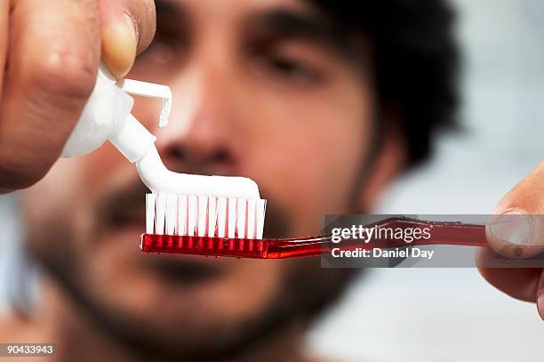 man applying toothpaste to brush - squeezing stock pictures, royalty-free photos & images