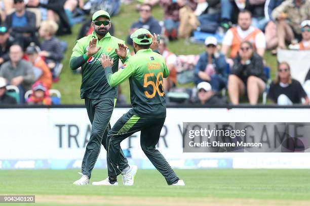 Mohammad Hafeez and Babar Azam of Pakistan celebrate the dismissal of Kane Williamson of New Zealand during the third game of the One Day...