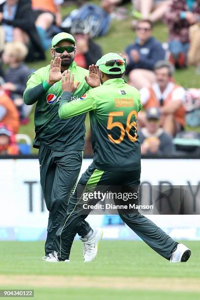 Mohammad Hafeez and Babar Azam of Pakistan celebrate the dismissal of Kane Williamson of New Zealand during the third game of the One Day...