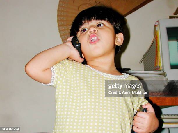 little baby girl talking on a cell phone - aparelho eletrónico de escuta imagens e fotografias de stock
