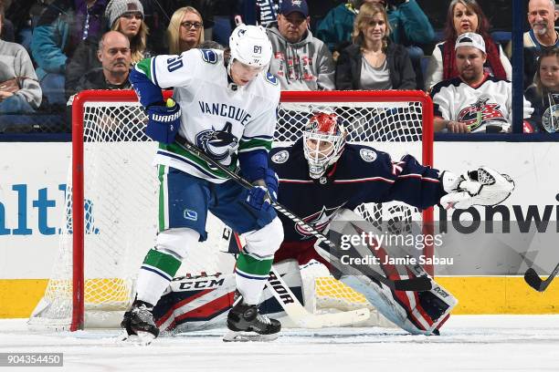 Goaltender Sergei Bobrovsky of the Columbus Blue Jackets defends the net as Markus Granlund of the Vancouver Canucks follows a loose puck during the...