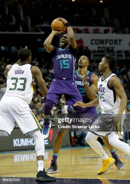 Kemba Walker of the Charlotte Hornets shoots over Ekpe Udoh of the Utah Jazz during their game at Spectrum Center on January 12, 2018 in Charlotte,...