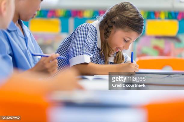 students working at their desk. - student writing stock pictures, royalty-free photos & images