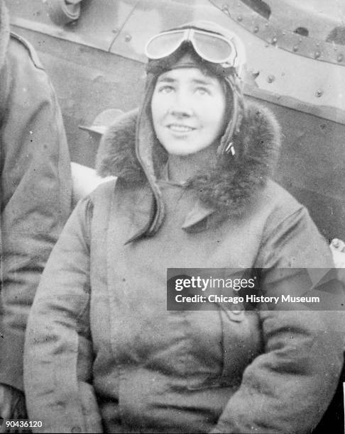 Portrait of Anne Morrow Lindbergh , pioneering aviator and wife of Charles Lindbergh, sitting at the side of an airplane on the ground in Chicago,...