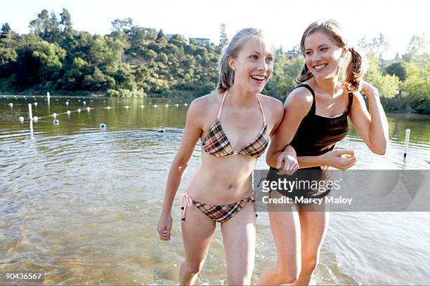 teenage sisters in a lake wearing swimsuits. - due sorelle foto e immagini stock