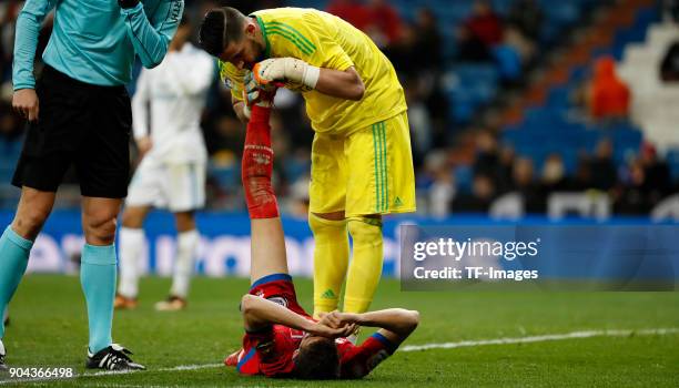 Kiko Casilla of Real Madrid on the ground and a player of Numancia helps during the Spanish Copa del Rey match between Real Madrid and Numancia at...