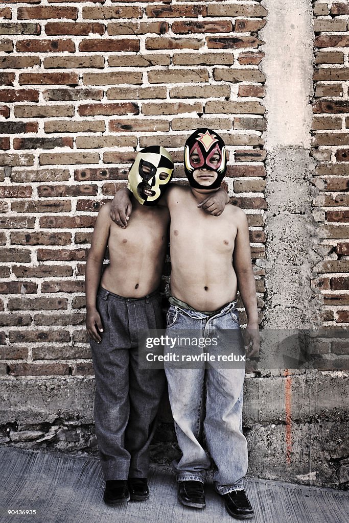 Two boys wearing Mexican  wrestling masks