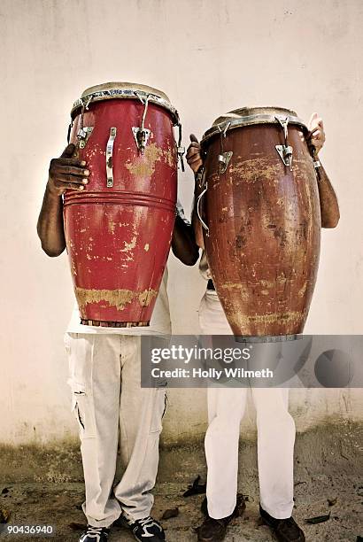 two men holding bongos in front of their faces - bongo foto e immagini stock