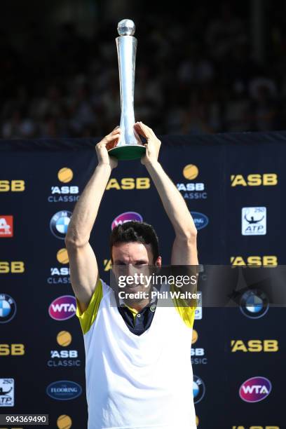Roberto Bautista Agut of Spain holds up the trophy following his Mens Singles Final win over Juan Martin Del Potro of Argentina during day six of the...