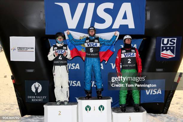 Guangpu Qi of China in second place, Maxim Burov of Russia in first place and Anton Kushnir of Belarus in third place celebrate on the podium in the...