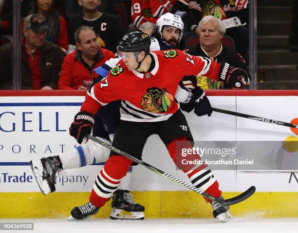 Lance Bouma of the Chicago Blackhawks pins Mathieu Perreault of the Winnipeg Jets against the boards at the United Center on January 12, 2018 in...