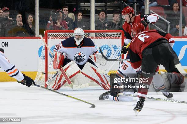 Goalie Al Montoya of the Edmonton Oilers positions himself for a save on the shot by Jakob Chychrun of the Arizona Coyotes as Darnell Nurse of the...