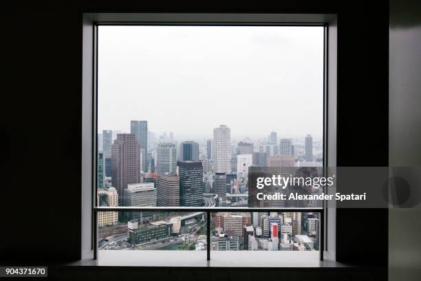 osaka skyline seen through square window - marco de ventana fotografías e imágenes de stock