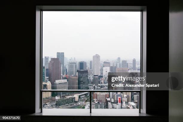 osaka skyline seen through square window - window frame stock pictures, royalty-free photos & images