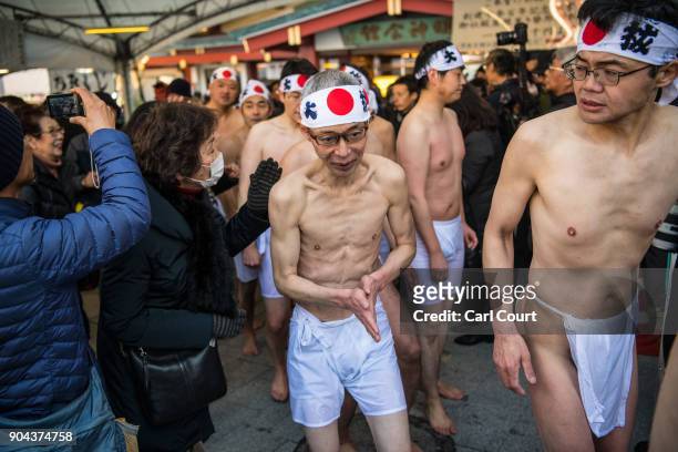 Men leave after taking part in a purification ritual that involved pouring ice-cold water over themselves at Kanda Myojin shrine on January 13, 2018...