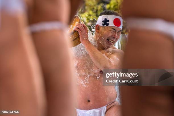 Man pours ice-cold water over himself during a purification ritual at Kanda Myojin shrine on January 13, 2018 in Tokyo, Japan. The coming of age...