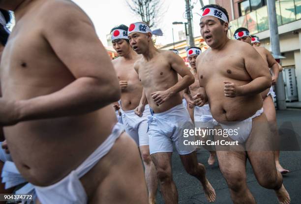 Men warm up as they prepare to take part in a purification ritual that involves pouring ice-cold water over themselves at Kanda Myojin shrine on...