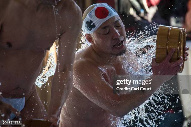 Man pours ice-cold water over himself during a purification ritual at Kanda Myojin shrine on January 13, 2018 in Tokyo, Japan. The coming of age...