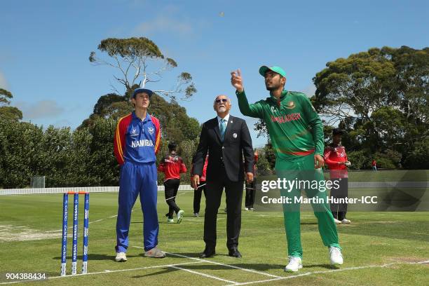 Lohan Louwrens of Namibia, ICC Match Official Dev Govindjee and Saif Hassan of Bangaldesh toss the coin during the ICC U19 Cricket World Cup match...