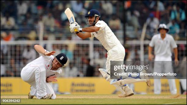 Mahendra Singh Dhoni of India plays a shot past England fielder Ian Bell during the 1st Test match between India and England at MA Chidambaram...